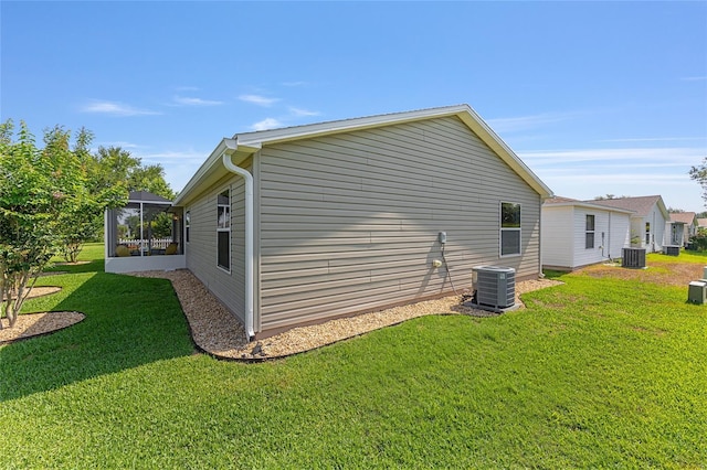 view of side of home with a lawn and central AC unit