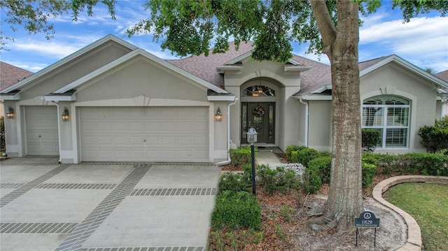 1828 Hollow Branch Way, The Villages, FL 32162 - view of front of property with stucco siding, a shingled roof, driveway, and a garage