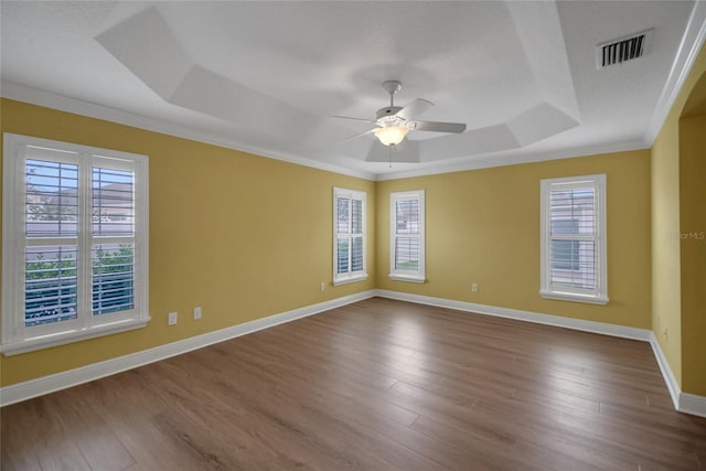1828 Hollow Branch Way, The Villages, FL 32162 - unfurnished room featuring a raised ceiling, healthy amount of natural light, a ceiling fan, dark wood-type flooring, and ornamental molding