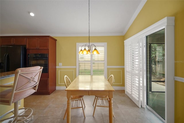 1828 Hollow Branch Way, The Villages, FL 32162 - dining area featuring a chandelier, a decorative wall, crown molding, and a wainscoted wall