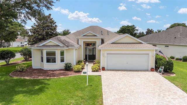 616 Hartford Ln, The Villages, FL 32162 - ranch-style home featuring a front yard, a garage, decorative driveway, and a shingled roof