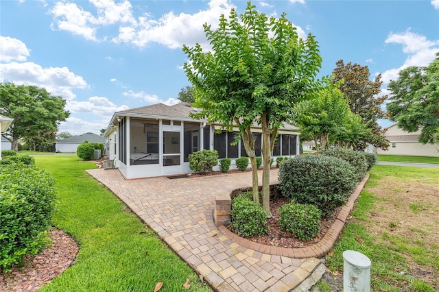 616 Hartford Ln, The Villages, FL 32162 - rear view of property with a sunroom, a patio area, a yard, and a shingled roof