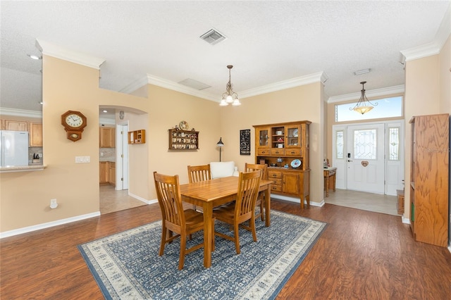 616 Hartford Ln, The Villages, FL 32162 - dining room with dark wood-style flooring, arched walkways, crown molding, and baseboards