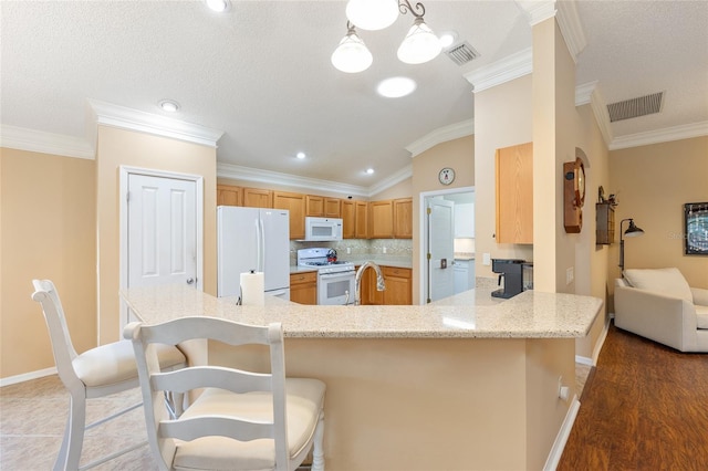 616 Hartford Ln, The Villages, FL 32162 - kitchen featuring white appliances, baseboards, ornamental molding, a kitchen breakfast bar, and vaulted ceiling