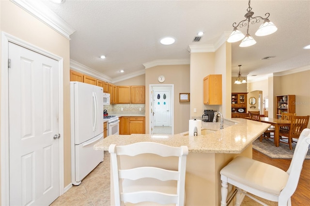 616 Hartford Ln, The Villages, FL 32162 - kitchen featuring white appliances, a peninsula, lofted ceiling, crown molding, and a sink