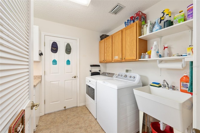 616 Hartford Ln, The Villages, FL 32162 - laundry area featuring independent washer and dryer, a textured ceiling, cabinet space, and light tile patterned floors