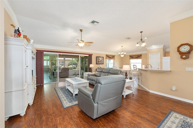 616 Hartford Ln, The Villages, FL 32162 - living room featuring crown molding, dark wood-type flooring, plenty of natural light, a chandelier, and baseboards