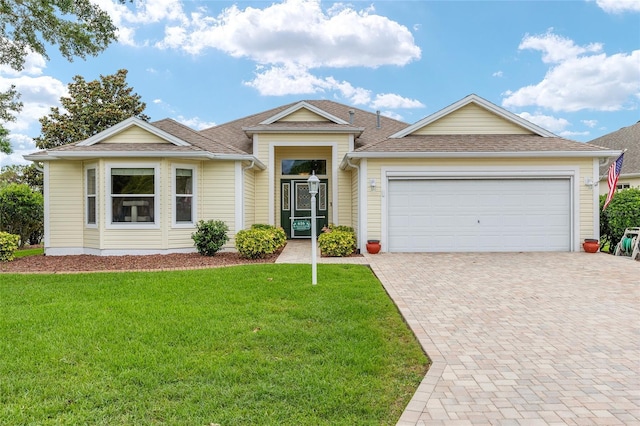 616 Hartford Ln, The Villages, FL 32162 - ranch-style home featuring decorative driveway, a garage, a front lawn, and a shingled roof