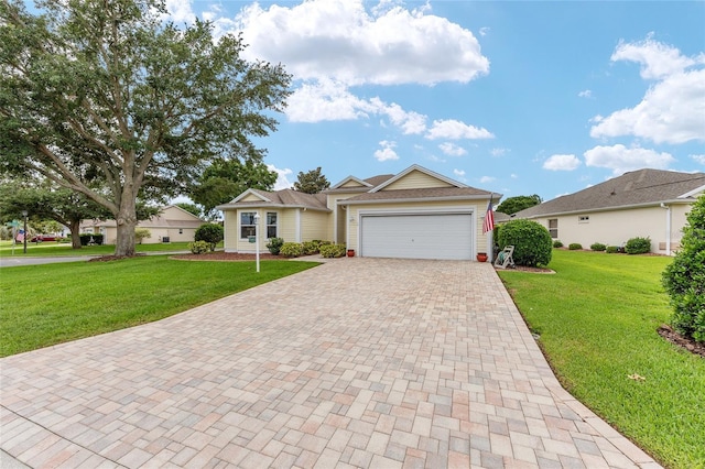 616 Hartford Ln, The Villages, FL 32162 - ranch-style home featuring decorative driveway, a front lawn, and an attached garage