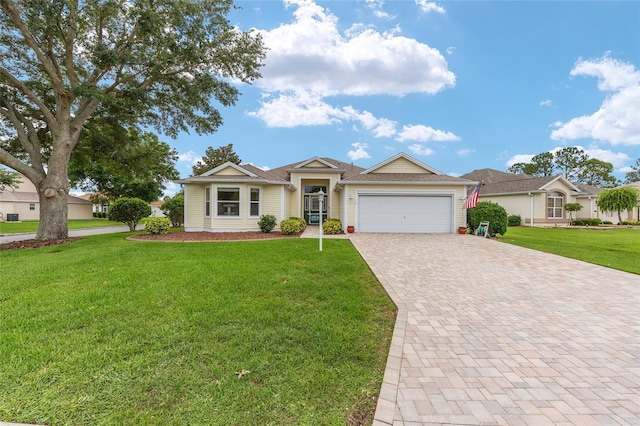 616 Hartford Ln, The Villages, FL 32162 - ranch-style house with decorative driveway, an attached garage, and a front yard