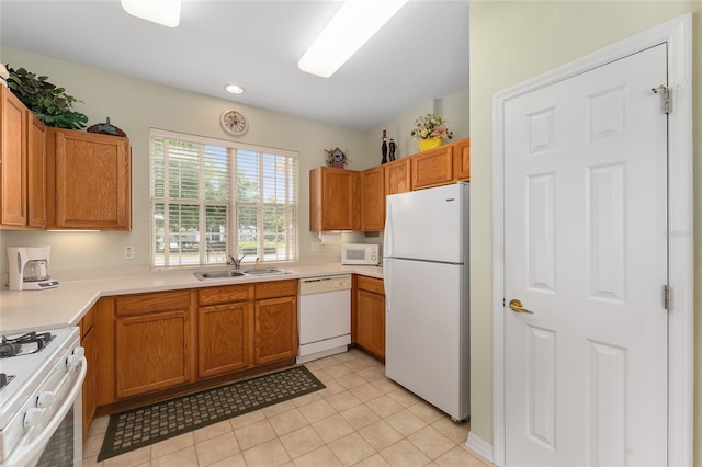 12687 SE 90th Ter, Summerfield, FL 34491 - kitchen with white appliances, a sink, light countertops, light tile patterned floors, and brown cabinets