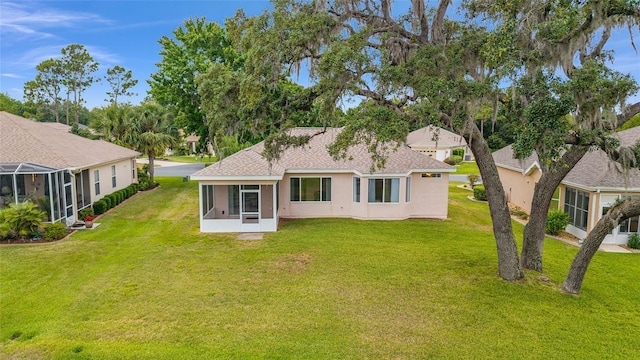 12687 SE 90th Ter, Summerfield, FL 34491 - rear view of house featuring a sunroom, stucco siding, and a lawn