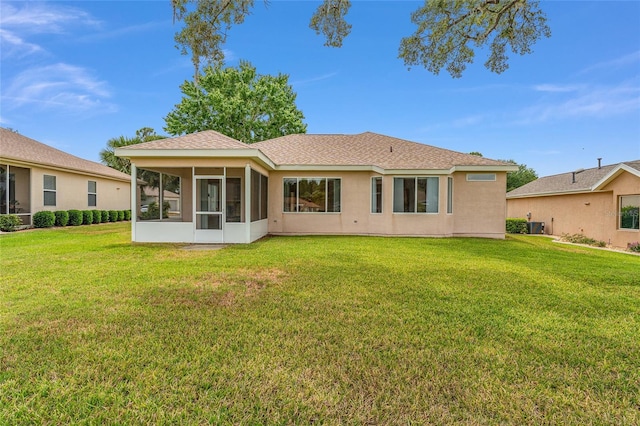 12687 SE 90th Ter, Summerfield, FL 34491 - rear view of house with a sunroom, a yard, stucco siding, and roof with shingles
