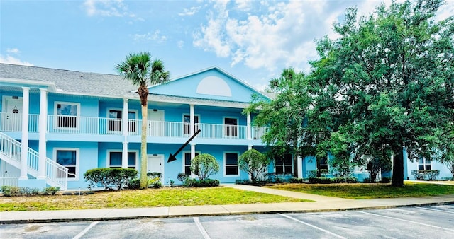 view of building exterior featuring uncovered parking and stairway