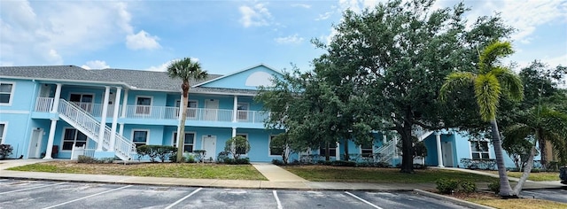 view of building exterior with uncovered parking and stairs
