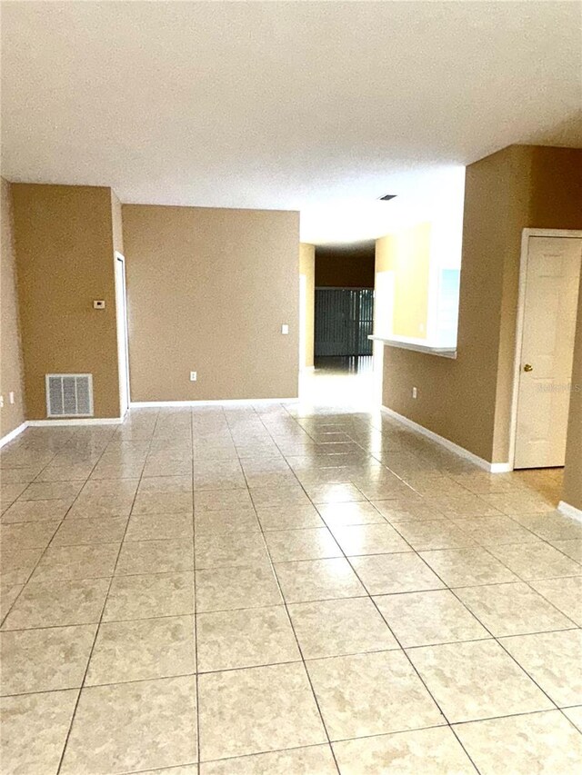 spare room with light tile patterned floors and baseboards