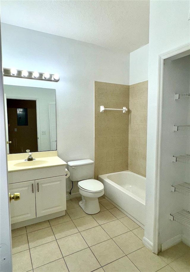full bathroom with tile patterned flooring, a tub, toilet, vanity, and a textured ceiling