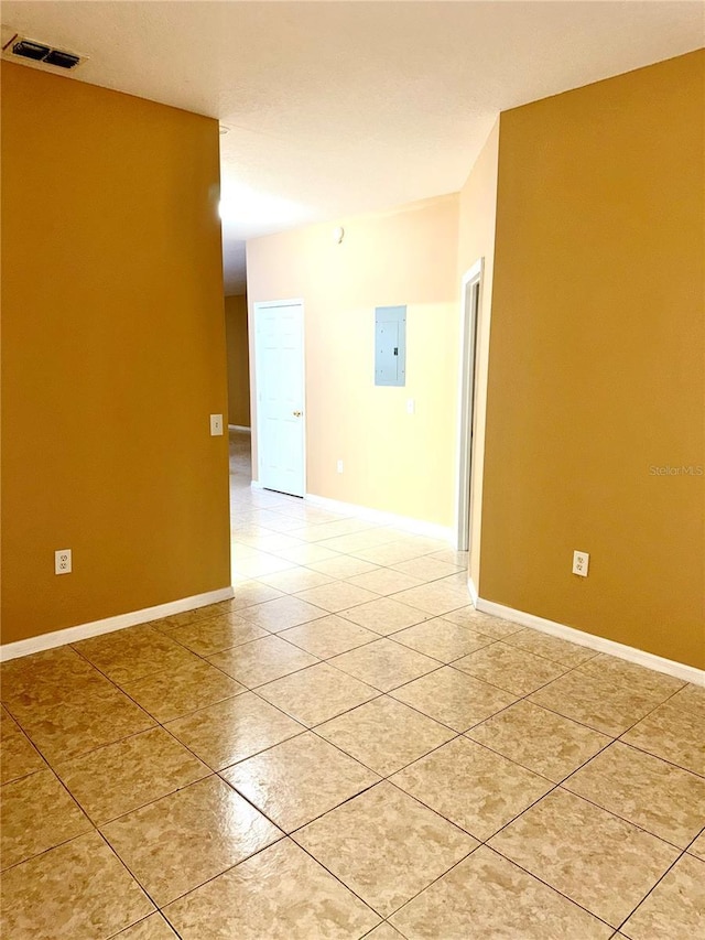 spare room with light tile patterned floors and baseboards