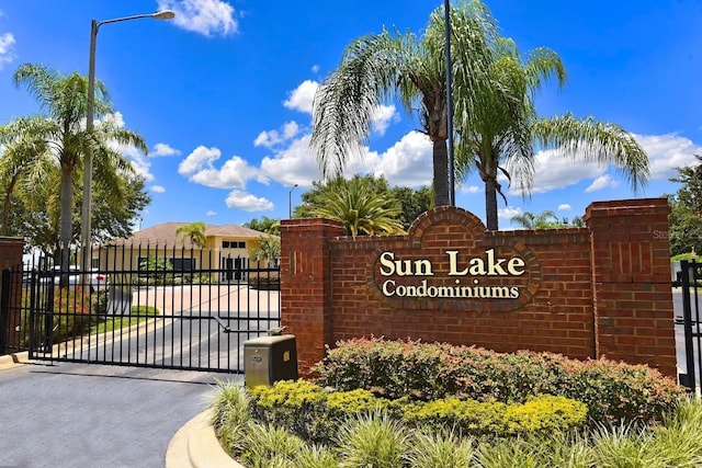 community sign featuring a gate and fence
