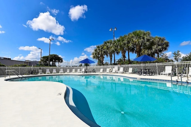community pool with fence and a patio area