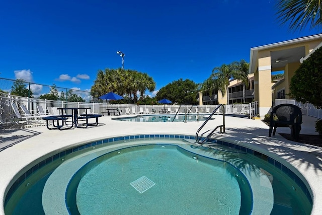 community pool with fence and a patio area