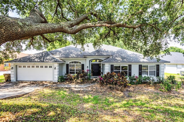 ranch-style house featuring roof with shingles, stucco siding, a garage, and concrete driveway