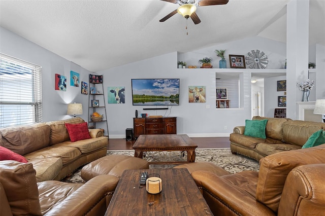 living room with vaulted ceiling, ceiling fan, wood finished floors, baseboards, and a textured ceiling