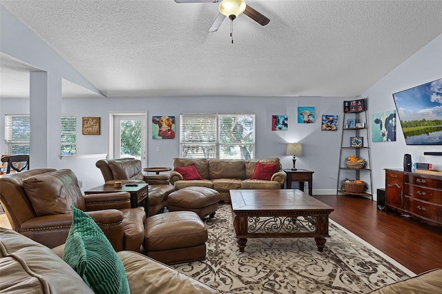 living area with vaulted ceiling, wood finished floors, ceiling fan, and a textured ceiling