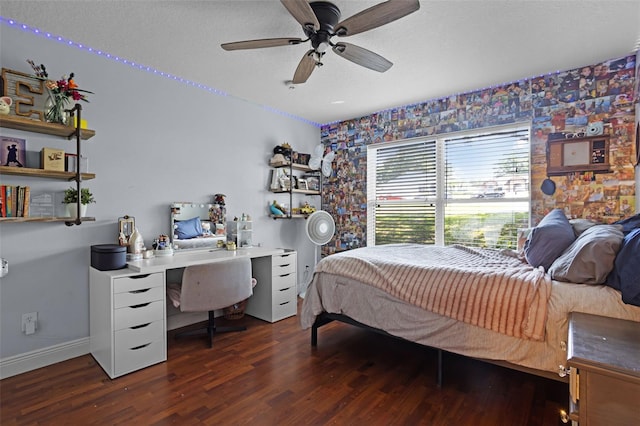 bedroom with wood finished floors, baseboards, an office area, a textured ceiling, and a ceiling fan