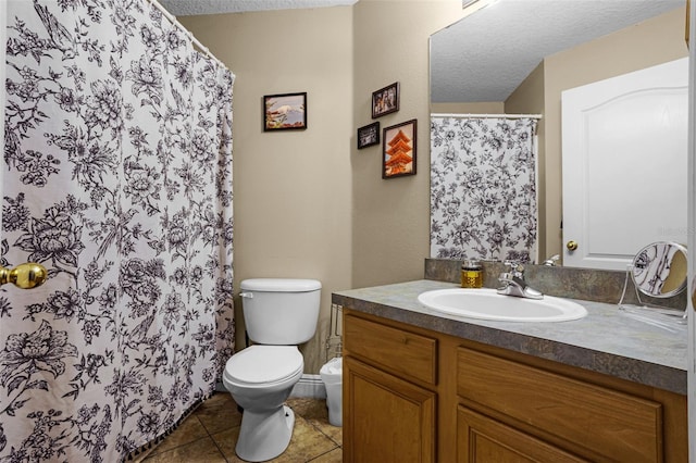 full bathroom featuring toilet, vanity, tile patterned floors, a textured ceiling, and a shower with curtain