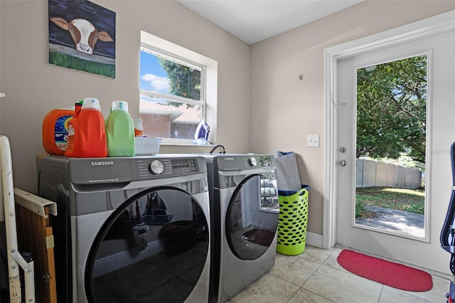 laundry room with washing machine and clothes dryer and tile patterned floors