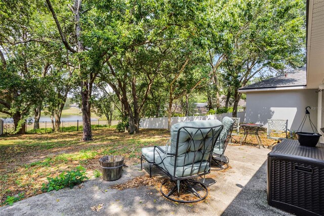 view of patio / terrace featuring a fenced backyard, central AC, and a water view