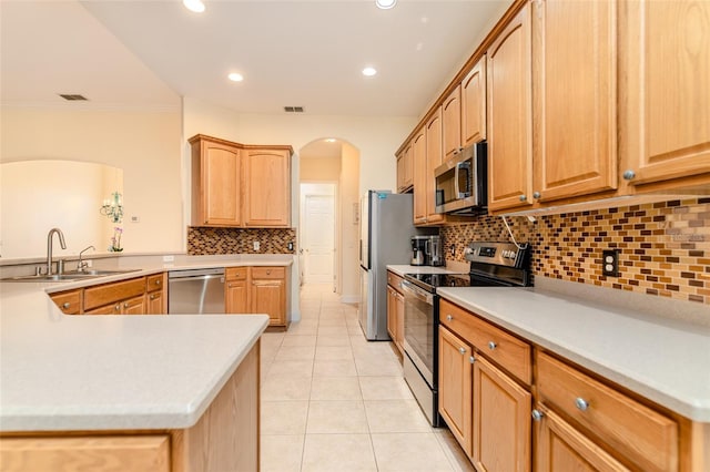 537 Montage Ln, Kissimmee, FL 34759 - kitchen with stainless steel appliances, a sink, arched walkways, light tile patterned flooring, and backsplash
