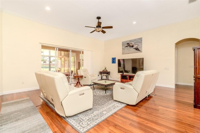 537 Montage Ln, Kissimmee, FL 34759 - living room featuring arched walkways, a ceiling fan, ornamental molding, wood finished floors, and baseboards