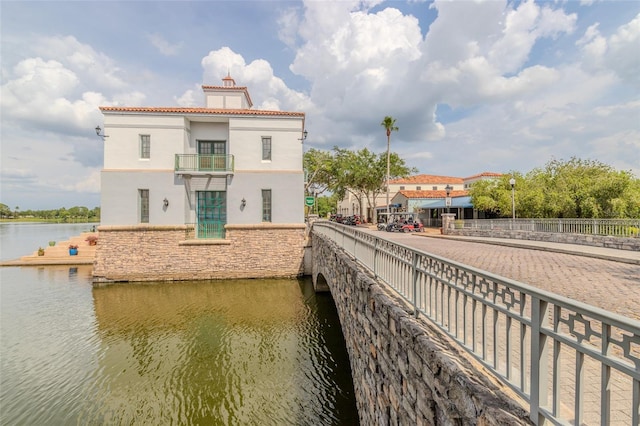 537 Montage Ln, Kissimmee, FL 34759 - rear view of house featuring stucco siding, a water view, a chimney, a balcony, and stone siding