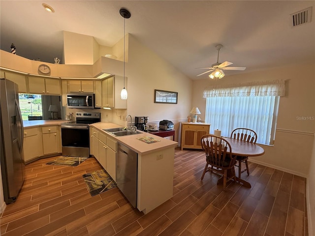239 Juniper Way, Tavares, FL 32778 - kitchen featuring appliances with stainless steel finishes, a sink, a peninsula, a ceiling fan, and dark wood finished floors