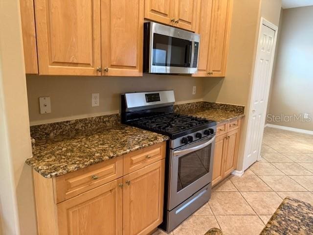 3083 Pinnacle Ct, Clermont, FL 34711 - kitchen with appliances with stainless steel finishes, dark stone counters, and light tile patterned flooring