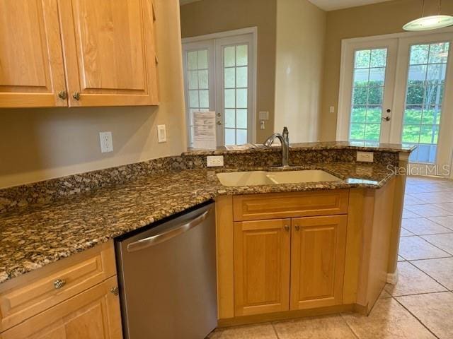 3083 Pinnacle Ct, Clermont, FL 34711 - kitchen with stainless steel dishwasher, french doors, a peninsula, dark stone counters, and light tile patterned flooring