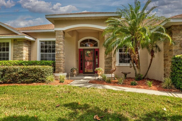 3141 Brighton Rd, Eustis, FL 32726 - property entrance with stucco siding, a yard, and stone siding