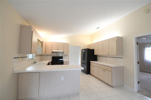 kitchen featuring black appliances, light brown cabinets, under cabinet range hood, a sink, and a peninsula