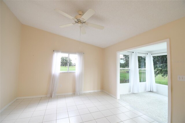spare room featuring vaulted ceiling, ceiling fan, light tile patterned flooring, and baseboards