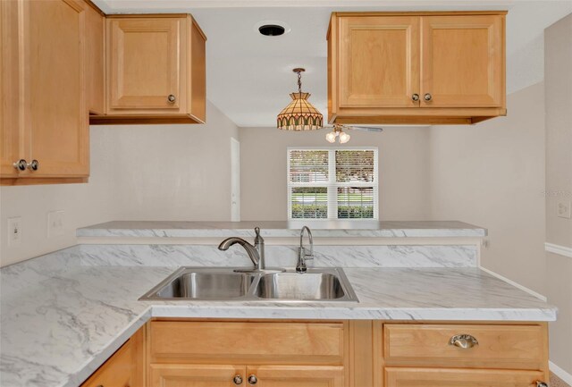 kitchen featuring a sink, light brown cabinets, and light stone counters