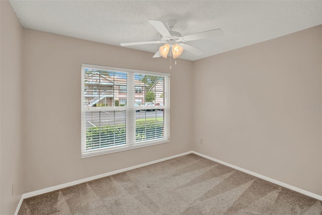 unfurnished room with carpet, a textured ceiling, baseboards, and ceiling fan