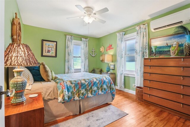 1301 N Ave, Tavares, FL 32778 - bedroom with a wall unit AC, multiple windows, wood finished floors, and ceiling fan