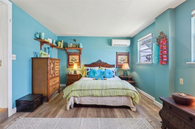 1301 N Ave, Tavares, FL 32778 - bedroom featuring a wall unit AC, wood finished floors, and baseboards