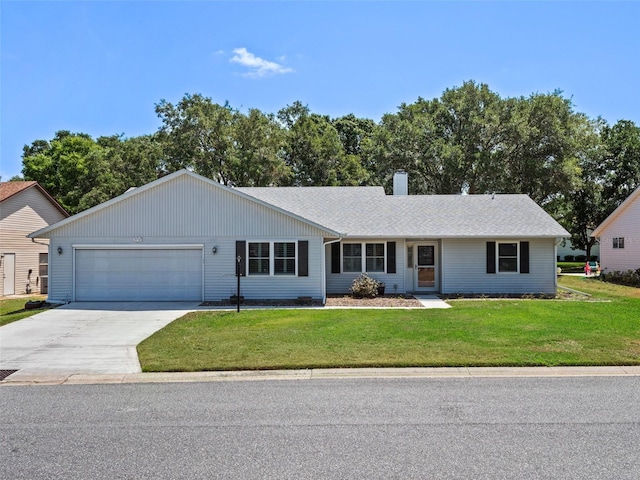 ranch-style home with driveway, a garage, a front lawn, and a chimney