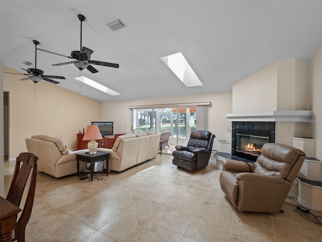 living room with lofted ceiling, a skylight, a fireplace, and ceiling fan