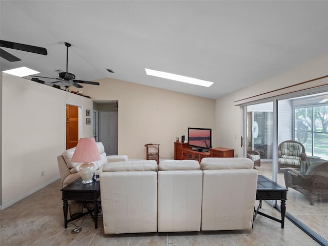 living area featuring lofted ceiling, a skylight, and ceiling fan