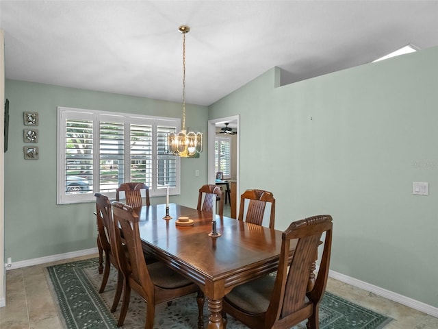 dining area with a chandelier, baseboards, and lofted ceiling