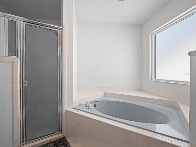 full bathroom with a shower stall and a bath